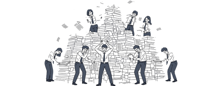 書類の山に囲まれ、既存システムの把握に困っている担当者たちのイメージ