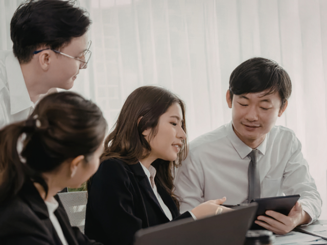 オフィスで打ち合わせするチーム（事例①イメージ）
